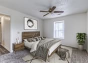 Thumbnail 7 of 30 - A bedroom with a bed, nightstand, and a ceiling fan.