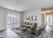 Thumbnail 4 of 30 - A living room with a grey couch and a coffee table.