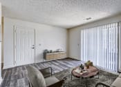 Thumbnail 6 of 30 - A living room with a grey couch and a coffee table.