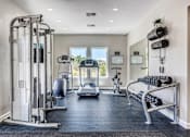Thumbnail 30 of 30 - A well-equipped gym with a variety of exercise machines and a bench for resting.