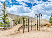 Thumbnail 21 of 30 - A playground with a slide, swings, and a climbing frame.