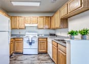 Thumbnail 20 of 30 - A kitchen with wooden cabinets and a white refrigerator.