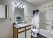 Thumbnail 15 of 30 - A bathroom with a sink, mirror, toilet, and bathtub.
