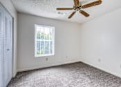 Thumbnail 10 of 30 - A room with a ceiling fan and a window with blinds.