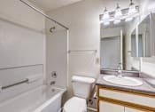 Thumbnail 9 of 30 - A white toilet sits next to a sink in a bathroom.