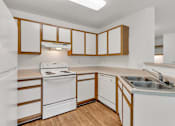 Thumbnail 24 of 24 - an empty kitchen with white appliances and wooden cabinets