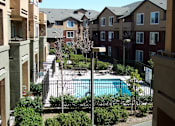 Thumbnail 1 of 6 - an apartment building with a pool in the middle