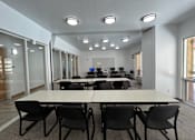 Thumbnail 7 of 18 - A conference room with a long table and chairs.