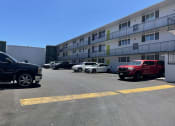 Thumbnail 23 of 27 - a parking lot with cars in front of a building