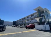 Thumbnail 27 of 27 - a building with a parking lot and cars in front of it
