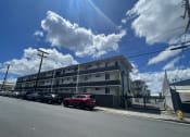 Thumbnail 22 of 27 - a building on a city street with cars parked in front of it