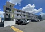 Thumbnail 18 of 27 - a large white building with cars parked in front of it