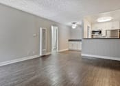 Thumbnail 3 of 6 - an empty living room and kitchen with wood flooring