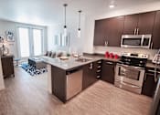 Thumbnail 15 of 20 - A modern kitchen with a large island and stainless steel appliances.at Cadence Apartments, HAYWARD, 94544