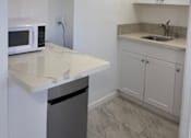 Thumbnail 9 of 13 - A kitchen with white cabinets and a countertop.