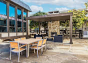 Thumbnail 12 of 41 - A patio with a table and chairs and a fireplace.