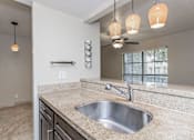 Thumbnail 30 of 41 - A modern bathroom with a granite countertop and a stainless steel sink.