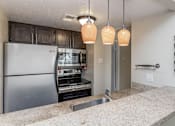 Thumbnail 28 of 41 - A kitchen with a stainless steel refrigerator and a built-in oven.