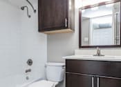 Thumbnail 41 of 41 - A white toilet sits in a bathroom next to a bathtub.