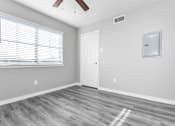 Thumbnail 40 of 41 - A room with a white door, a window with blinds, and a ceiling fan.
