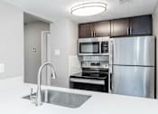 Thumbnail 36 of 41 - A kitchen with a stainless steel refrigerator, microwave, and oven.