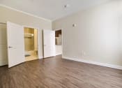 Thumbnail 16 of 23 - an empty living room with white walls and wood flooring