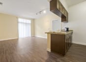 Thumbnail 22 of 23 - an empty living room with a kitchen and a window