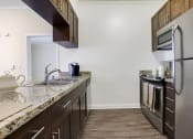 Thumbnail 19 of 23 - a kitchen with stainless steel appliances and granite counter tops
