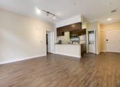 Thumbnail 15 of 23 - the living room and kitchen of an apartment with a hard wood floor