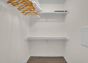 Thumbnail 43 of 53 - A white closet with a shelf and a hanger rack.