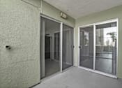 Thumbnail 47 of 53 - A room with a sliding glass door and a wall-mounted light fixture.
