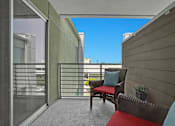 Thumbnail 48 of 53 - A balcony with a red cushion and a brown chair.