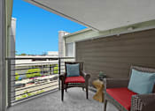 Thumbnail 49 of 53 - A balcony with two chairs and a small table.