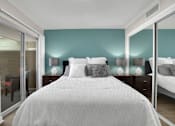 Thumbnail 39 of 53 - A bedroom with a large bed and two nightstands with lamps.