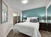 Thumbnail 40 of 53 - A bedroom with a large bed and a mirror on the wall.