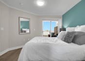 Thumbnail 41 of 53 - A bedroom with a large bed and a view of the outside through the window.