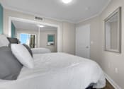 Thumbnail 42 of 53 - A bedroom with a large bed and a mirror on the wall.