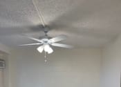 Thumbnail 11 of 13 - A room with a ceiling fan and tile flooring.