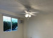 Thumbnail 10 of 13 - A room with a ceiling fan and a window.