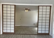 Thumbnail 3 of 13 - A room with a ceiling fan and sliding doors.