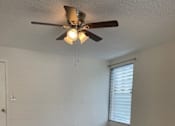 Thumbnail 5 of 13 - A room with a ceiling fan and a window with blinds.