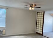 Thumbnail 2 of 13 - A room with a ceiling fan and light fixture, a window with blinds, and a wooden floor.