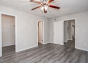 Thumbnail 31 of 58 - A room with a ceiling fan and wooden flooring.