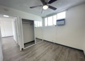 Thumbnail 11 of 27 - an empty living room with a ceiling fan and a closet