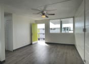 Thumbnail 7 of 27 - an empty living room with a ceiling fan and a window