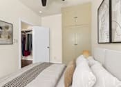 Thumbnail 8 of 13 - A bedroom with a bed, a wardrobe, and a ceiling fan.