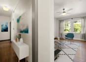 Thumbnail 7 of 25 - A room with a blue chair and a painting on the wall.