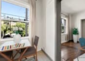 Thumbnail 4 of 25 - A dining room with a table and chairs is shown.