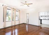 Thumbnail 14 of 25 - A room with a ceiling fan and wooden floors.