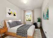 Thumbnail 8 of 25 - A bedroom with a bed, nightstand, and a painting on the wall.